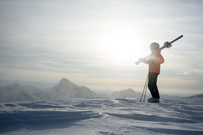 skier standing at the top of a snowy mountain