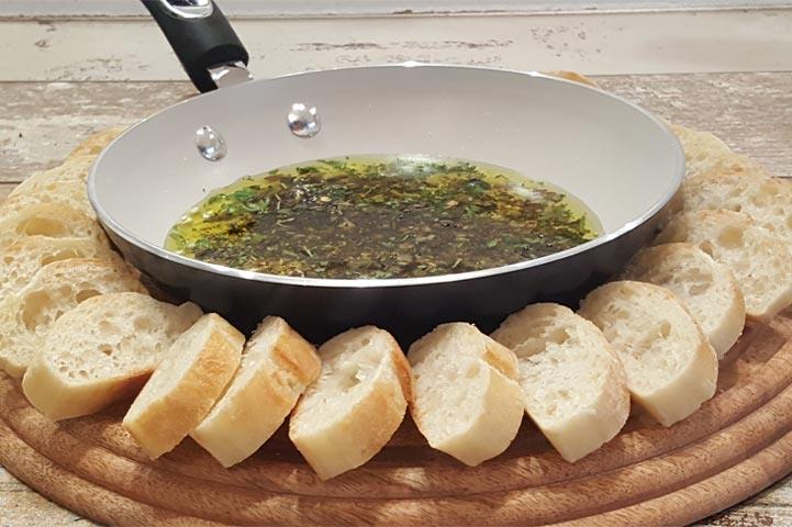 herb dip in a bowl surrounded by bread